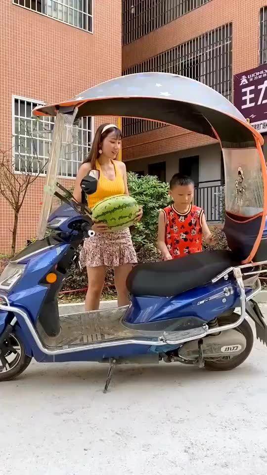 女子车前吃瓜,展现夏日休闲生活画卷